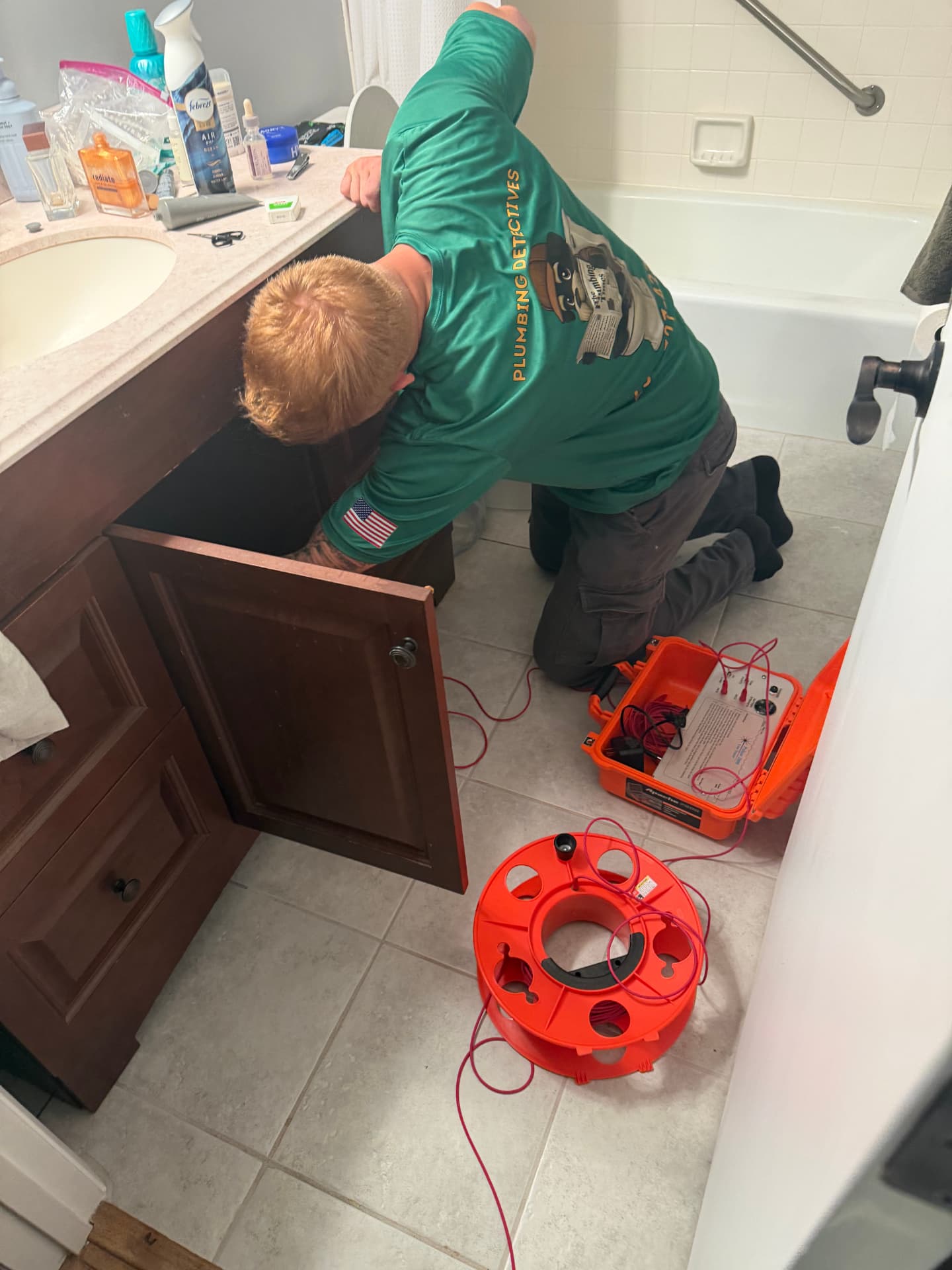 Technician isolating the target water line under a bathroom sink